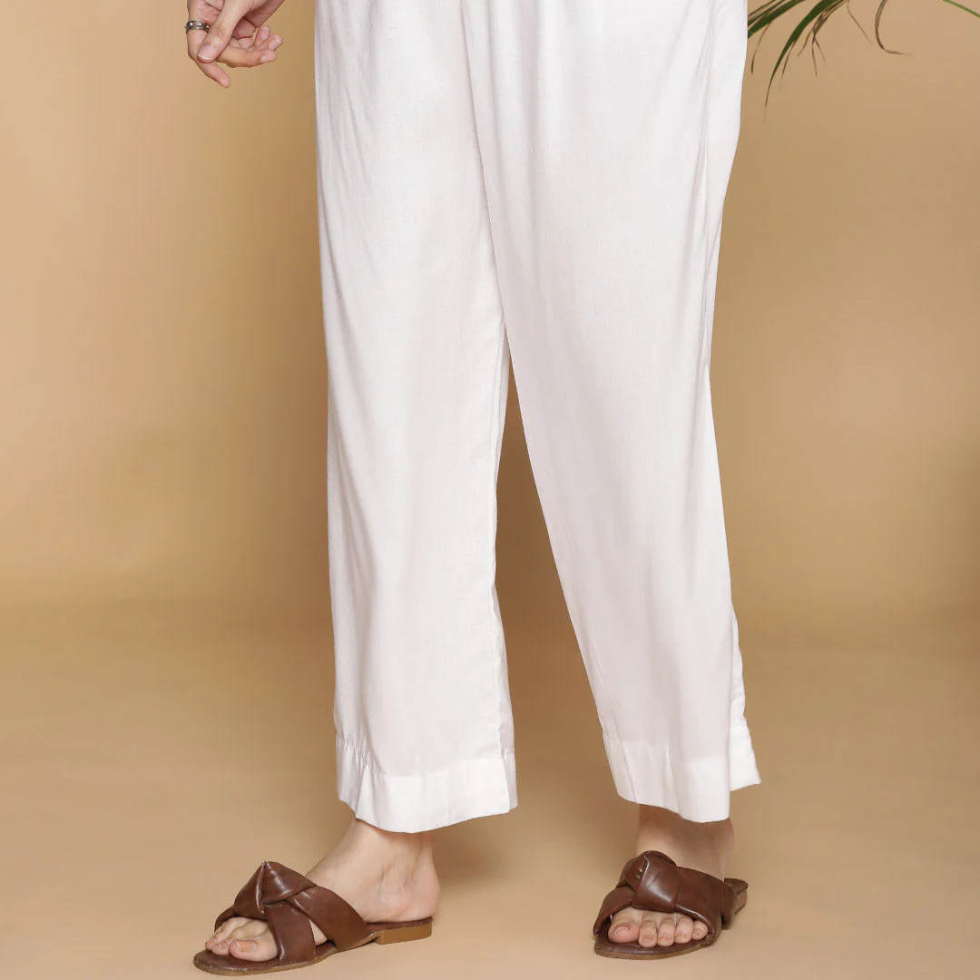 Person wearing white pants on a beige background